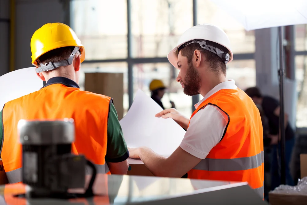 Warehouse worker talking on the phone holding clipboard in a large warehouse